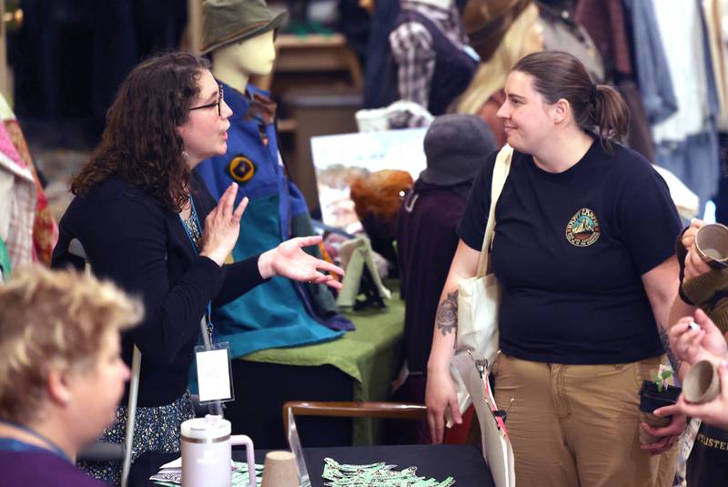 Visitors check out some of the tables Thursday, April 18, 2024, during Earth Fest at the Egyptian Theatre in DeKalb. The event, in honor of Earth Week, was presented by DeCarbon DeKalb, in partnership with NIU.