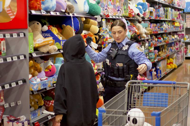 Joliet Police Officer Lauren Reposa shops with a child during the 36th annual Santa's Cops event on Saturday, Dec. 6, 2025, at Walmart, 401 Illinois Route 59, in  Shorewood.