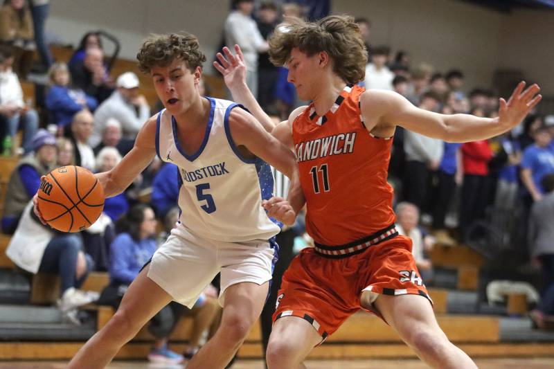 Woodstock’s Max Beard, left, drives against Sandwich’s Nick Michalek in varsity boys basketball on Tuesday, Feb. 11, 2025, at  Woodstock High School in Woodstock.