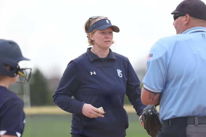 Plainfield South head coach Tara Miller talks with the umpire between at-bat agianst Joliet Catholic on Wednesday, April 10, 2024.