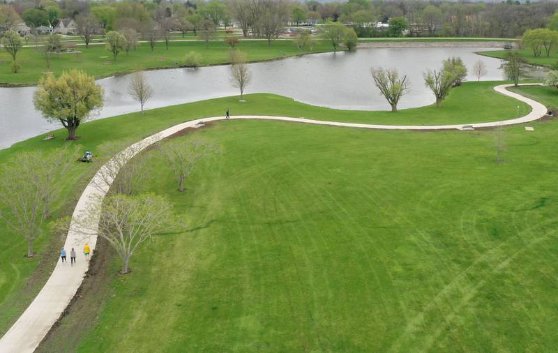 A person takes a stroll on the new walking path on Thursday, April 16, 2026 at Baker Lake in Peru. The project is now complete and the park is back open to the public. Construction work began last October and included a 10-foot-wide concrete path, with secondary concrete paths also added, connecting the new parking lot near Lighted Way to the parking lot, playground, and shelter on the west side of Baker Lake. The new path is 2 feet than the current one.