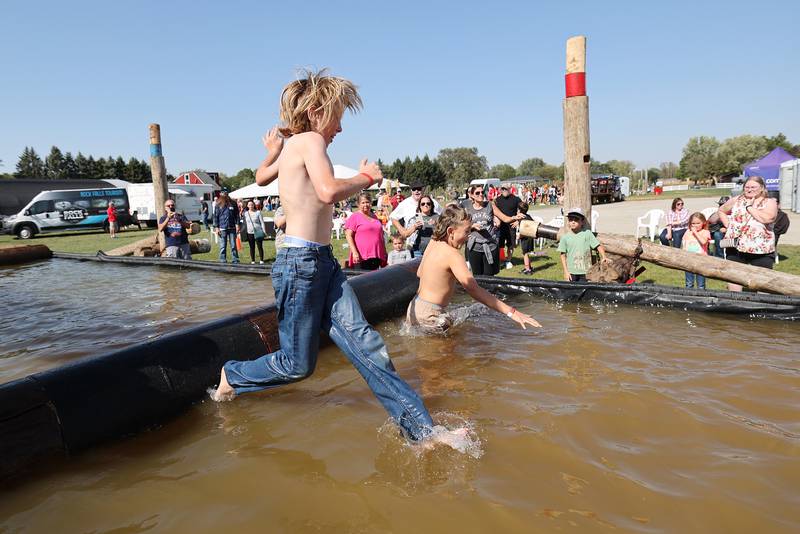 Henry Hartman (left), 10, of Morrison and Hunter Schueler, 9, of Rock Falls take a dip while trying their feet at log rolling Saturday, October 5, 2024. Kids were offered a chance to balance on a log at Rock Falls Tourism’s Lumberjack Show.