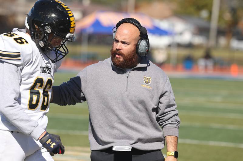 Joliet West head coach Dan Tito talks to Austin Perella between plays on Saturday.