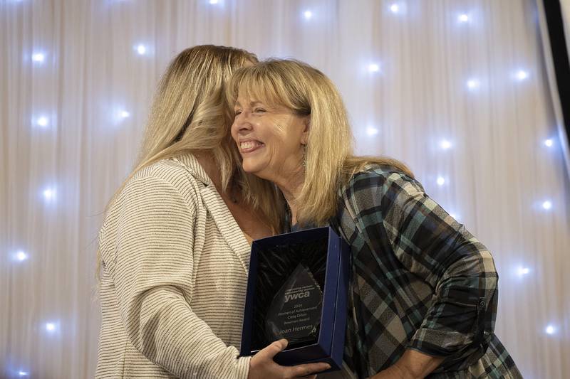 Joan Hermes (right) is presented with the Crete Dillon Bowman Award by Jaime Cos Thursday, April 18, 2024 at the YWCA Women of Achievement Luncheon. The award is given to a recipient who has exhibited outstanding volunteerism or leadership that has strengthened the community.