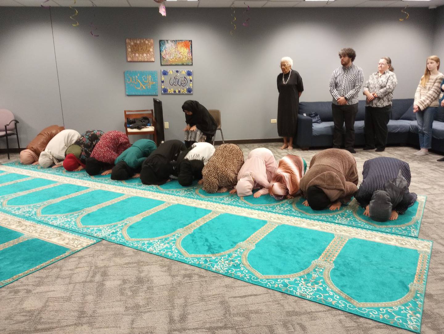Muslim women bow during prayer at the Islamic Center of Kane County in St. Charles on Wednesday night after breaking their fast during Ramadan. The center hosted an interfaith event to share the meaning of Islam’s holiest month.