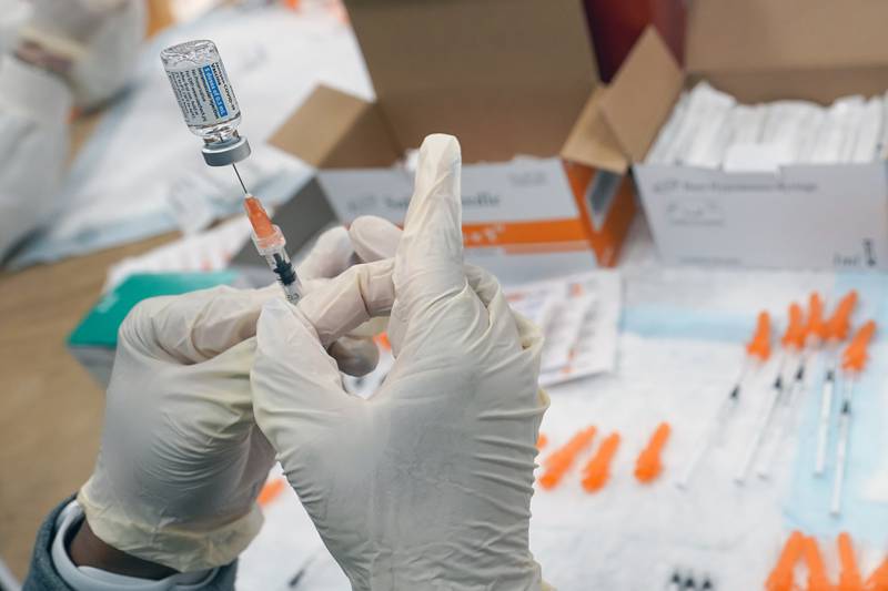 FILE - In this April 8, 2021, file photo, registered nurse fills a syringe with the Johnson & Johnson COVID-19 vaccine at a pop up vaccination site in the Staten Island borough of New York. Researchers and health officials have been monitoring the real-world performance of the COVID-19 vaccines to see how long protection lasts among vaccinated people. (AP Photo/Mary Altaffer, File)