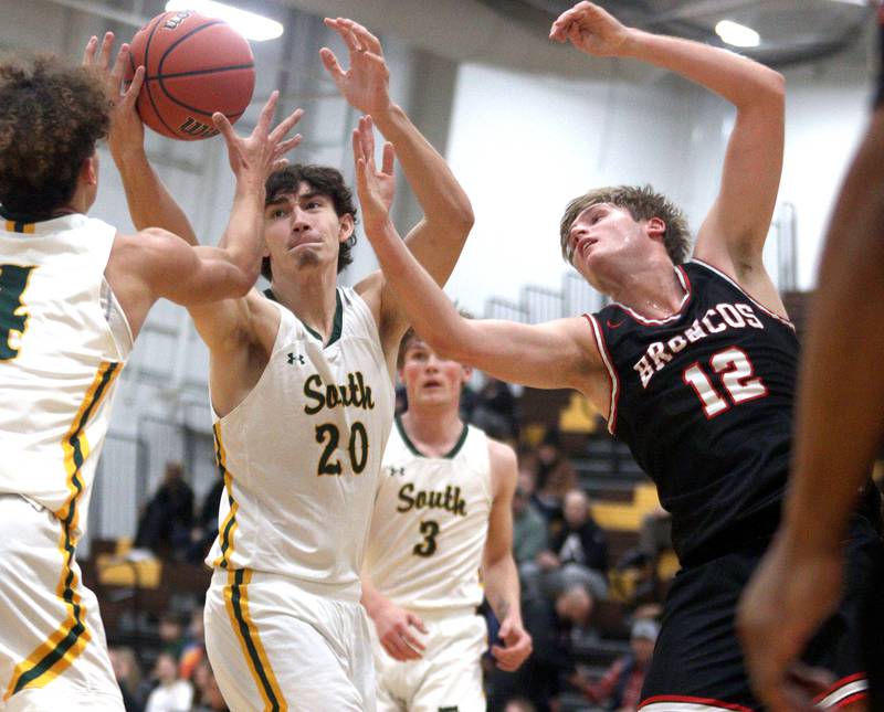 Crystal Lake South’s CJ Regillio, center, and  Barrington’s Alec Schmidts, right, battle in Hinkle Holiday Classic boys basketball tournament game action at Jacobs High School Tuesday.