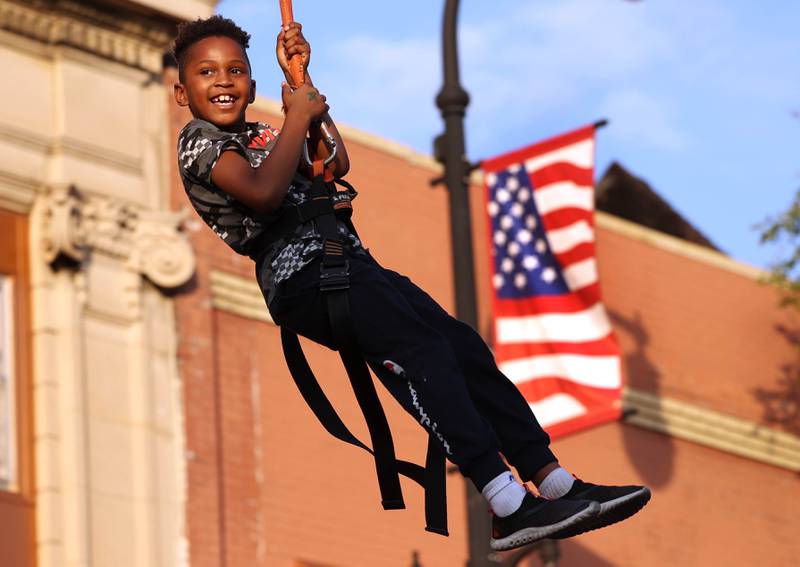 Asiyha Pipkins, 7, from DeKalb, rides the zipline Thursday, Oct. 2, 2025, during the Huskie Homecoming Block Party in downtown DeKalb.