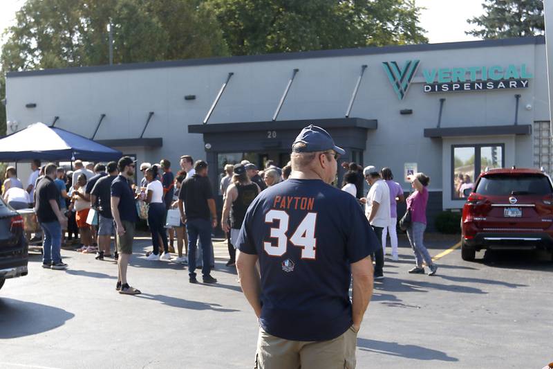 People wait in line for former Bears quarterback Jim McMahon to signs autographs and pose for pictures with customers during the grand opening of the Vertical Dispensary on Saturday, Sept. 30, 2023, in Cary. The dispensary has been open for about a month.