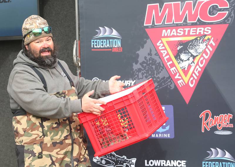 Tim Schwingle hands his basket of fish to the Illinois Department of Natural Resources that he caught during the annual Masters Walleye Circuit tournament on Friday, March 21, 2025 at the Spring Valley Boat Club.