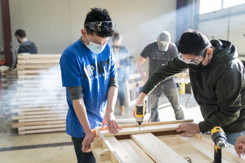 DeAndrae Valdez (left), 17, of Carpentersville, and Jesse Morales, 12, assemble a bed frame during a volunteer bed building event sponsored by the Sleep in Heavenly Peace organization on Saturday afternoon at the Algonquin Township Highway Department in Cary. The group builds and donates twin size beds to children and families in need around the area. The group had parts ready to build around 25 beds during the event.  Ryan Rayburn for Shaw Local