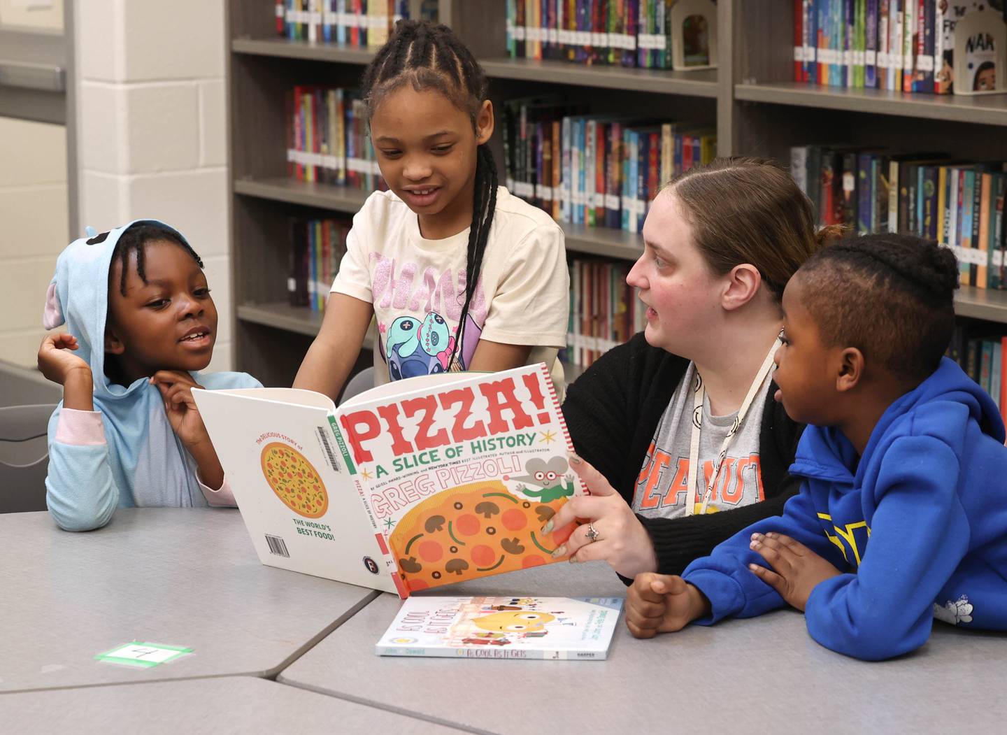 Mitchell Elementary School first grade teacher Cassandra Sprankle reads a book to some of her students Thursday, March 19, 2026, in the library at the school in DeKalb.