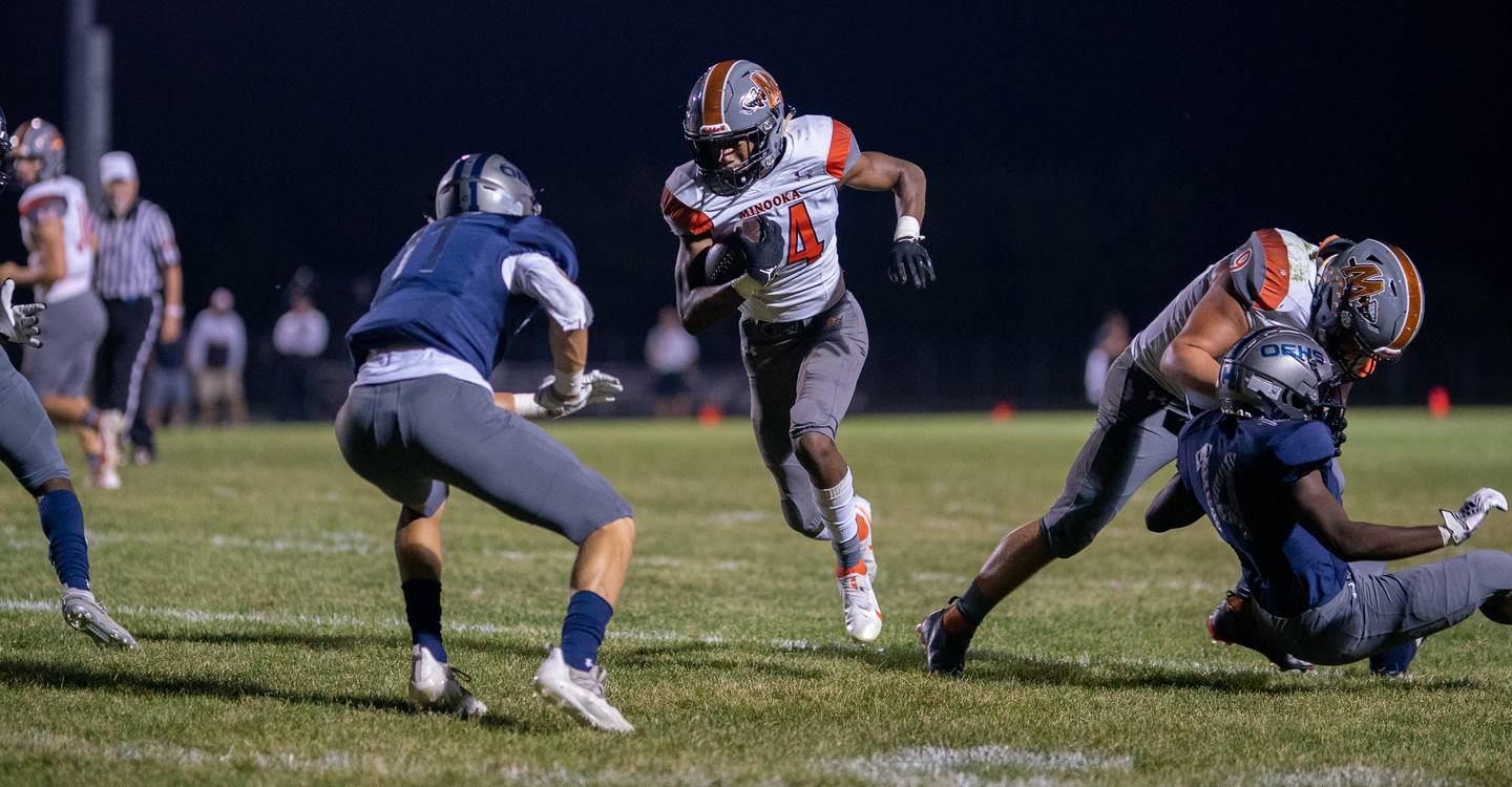 Minooka’s Malik Armstrong (14) carries the ball against Oswego East's Michael Polubinski (11) during a varsity football game at Oswego East High School in Oswego on Friday, Oct 1, 2021.