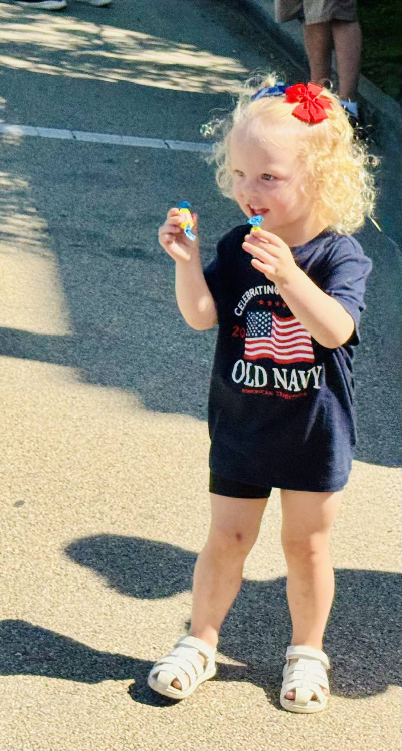 Ellie Harris, 2, holds up candy collected during Ottawa's Memorial Day parade Monday, May 25, in downtown Ottawa.