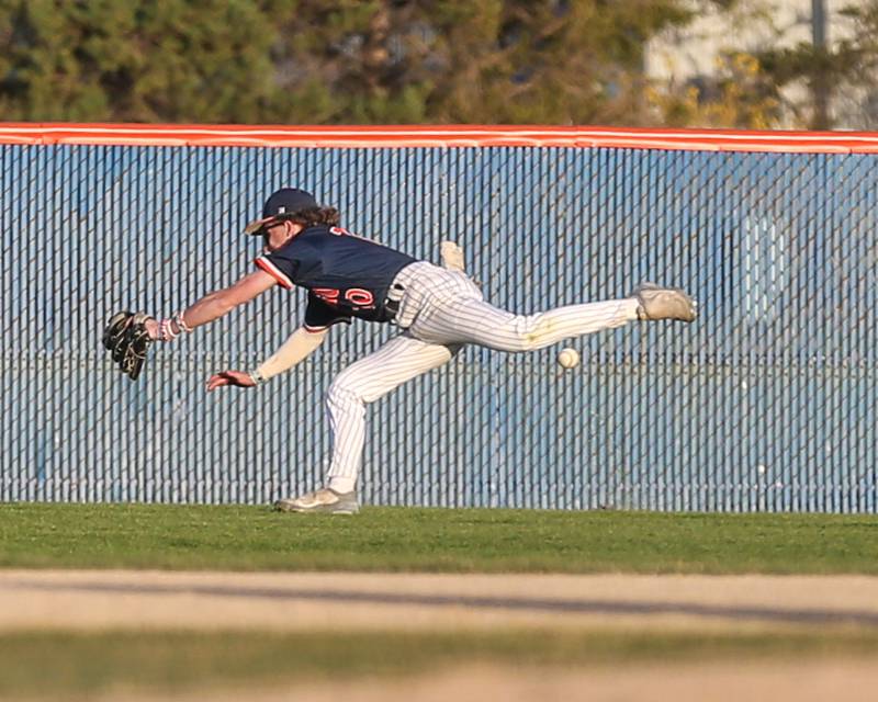 Oswego's TJ Harazin (10) dives unsuccessfully for a flyball during baseball game between Plainfield South at Oswego on Monday, April 14, 2025 in Oswego.