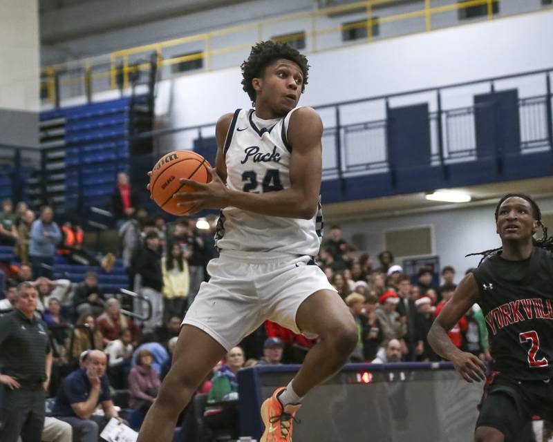 Oswego East's Dshaun Bolden (24) comes down with a pass into the post during their basketball game between Yorkville at Oswego East. Friday, Dec 19, 2025 in Oswego.