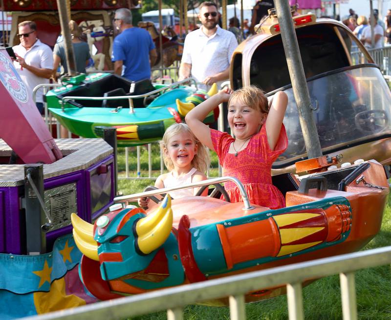 Julia White and Pearl Mariano have fun on the mini enterprise, one of the many carnival rides at the 2024 Sugar Grove Corn Boil on Friday, July 26, 2024.