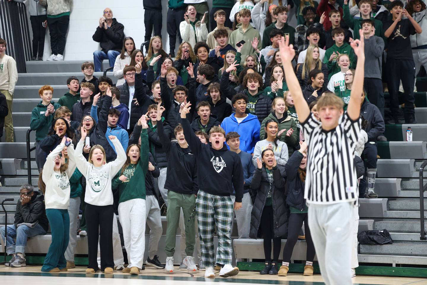 The Bishop McNamara student section cheers as varsity basketball player Coen Demack signals a good 3-pointer during River Valley Special Rec's game against Lincolnway Special Recreation Association on Friday, Jan. 30, 2026.