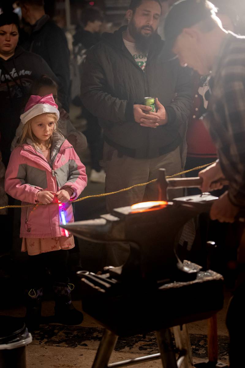Ruth Bishop, 6, of Dixon watches intently as a blacksmith from the John Deere Historic Site demonstrates his skills during the Dixon Christmas walk, Dec. 2, 2022.
