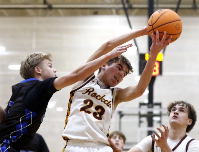 Richmond-Burton's William Gardner grabs a rebound over Woodstock's Rian Hahn Clifton  as his teammate, andon Nelson, looks at the ball during a Kishwaukee River Conference boys basketball game on Friay Jan. 9  2026, at Richmond-Burton High School, in Richmond.