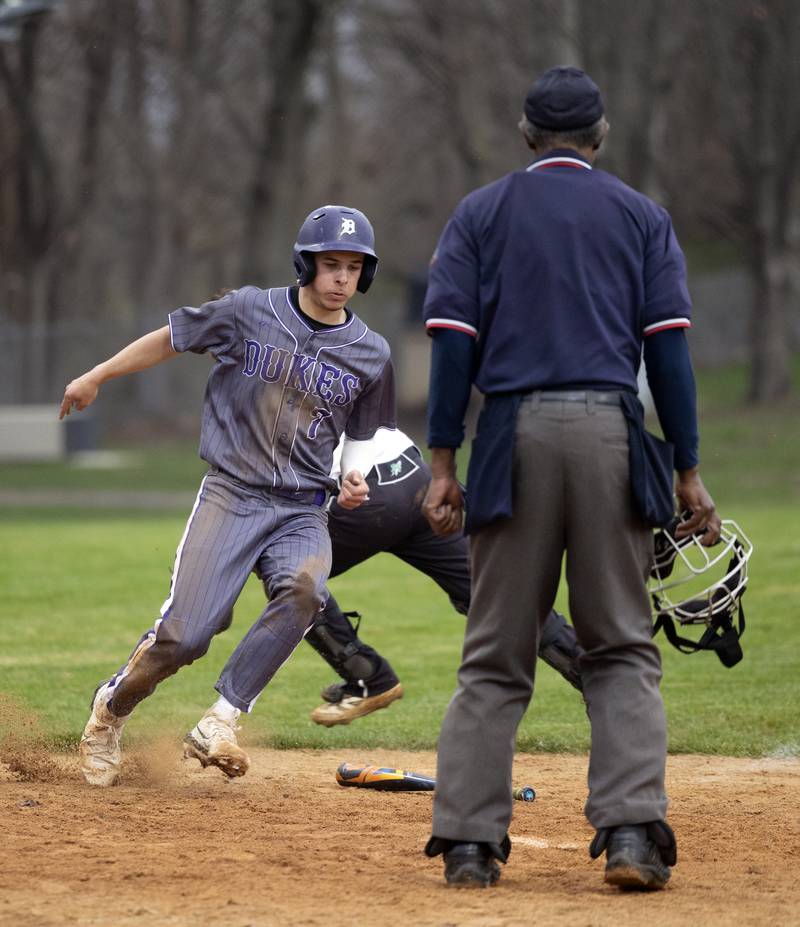 Dixon’s Eli Kirchoff moves around the Rock Falls catcher and the bat to score Thursday, April 9, 2026.