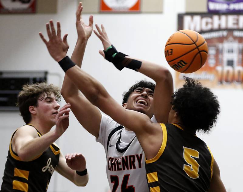 McHenry's Adam Anwar looses the ball as he is guarded by Jacobs' Ben Jurzak (left) and Jordan O'connor (right) during an IHSA Class 4A McHenry Regional basketball game on Wednesday, Feb. 26, 2025, at McHenry High School.