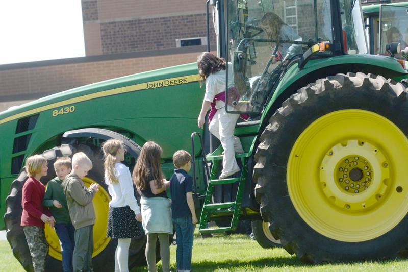 Oregon Elementary School students wait their turn to explore one of the farm tractors on display at the Oregon High School's FFA ag event on Friday, May 9, 2025.