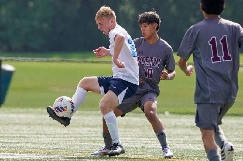 Downers Grove South's Ryan Deacy (22) plays the ball against Morton’s Yahir Aguilar (10) during a soccer match at Morton High School in Berwyn on Saturday, Oct. 5, 2024.