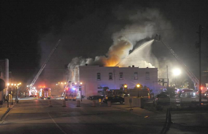 Smoke and flames emerge from an apartment outside Skoogs Pub & Grill on Sunday, May 10, 2015 downtown Utica.