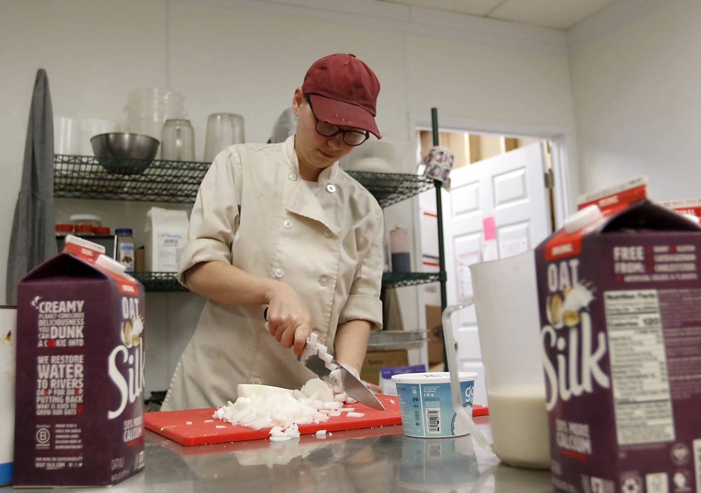 Corinna Sac, the owner of UpRising Bakery and Cafe, chops an onion Tuesday, Oct. 4, 2022, while working in the kitchen of the bakery and cafe at 2104 W. Algonquin Road in Lake in the Hills. After opening a bakery in 2021, Sac began hosting events to try and supplement her business' income. One of those events – a drag brunch – led to threats and vandalism but also an outpouring of support.