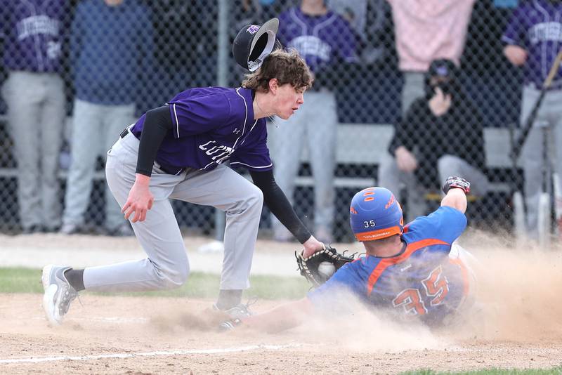 Genoa-Kingston's Evan Thompson scores on a wild pitch as Rockford Lutheran's Jackson Heidemann takes the throw during their game Tuesday, May 2, 2023, at Genoa-Kingston High School.