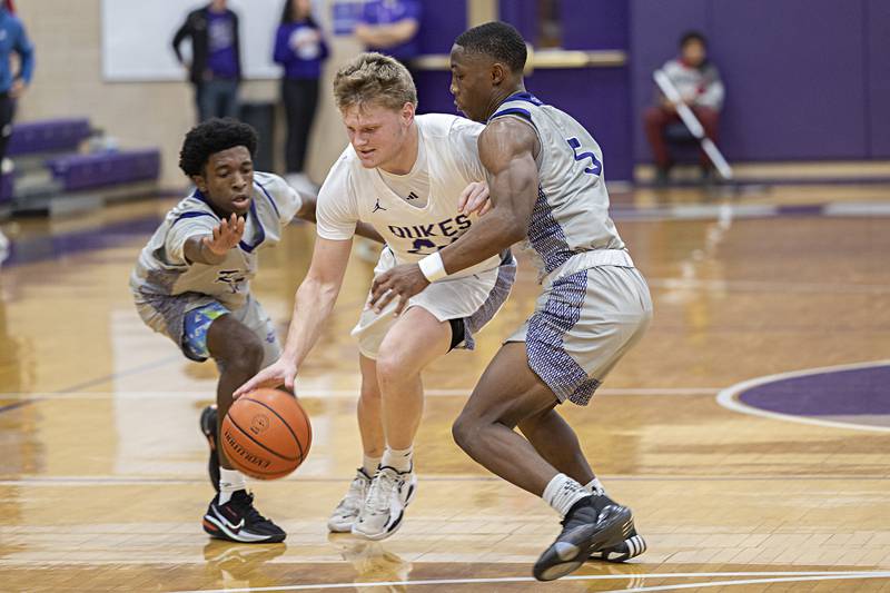 Dixon’s Eli Davidson splits Plano’s Amari Bryant (left) and Waleed Johnson Wednesday, Dec. 6, 2023 at Dixon High School.