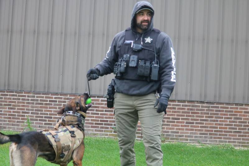 DeKalb police Sgt. Steve Parsons (right) is seen playing with Chase Oct. 22, 2025, outside the former GE plant in DeKalb.
