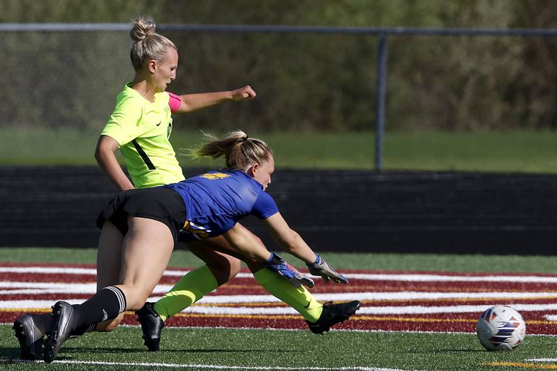 Johnsburg goalie Sophie Person dives for the ball as Richmond-Burton's Layne Frericks kicks the ball into the goal during the Kishwaukee River Conference Girls Soccer Tournament Championship Match on Wednesday, May 1, 2024, at Richmond-Burton High School.