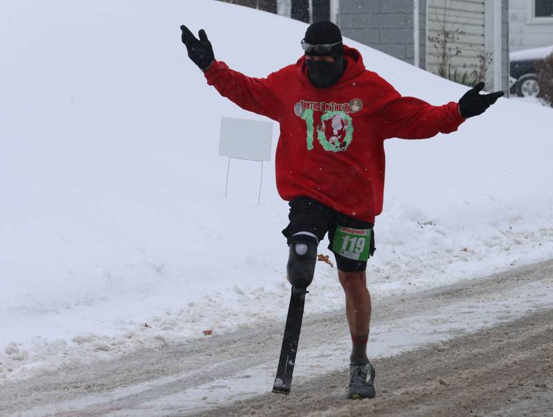 Tim Novak, known as “Juan Leg,” runs on ice and snow during the Santas on the Run 5K and one-mile walk on Saturday, Nov. 29, 2025 in Spring Valley.
