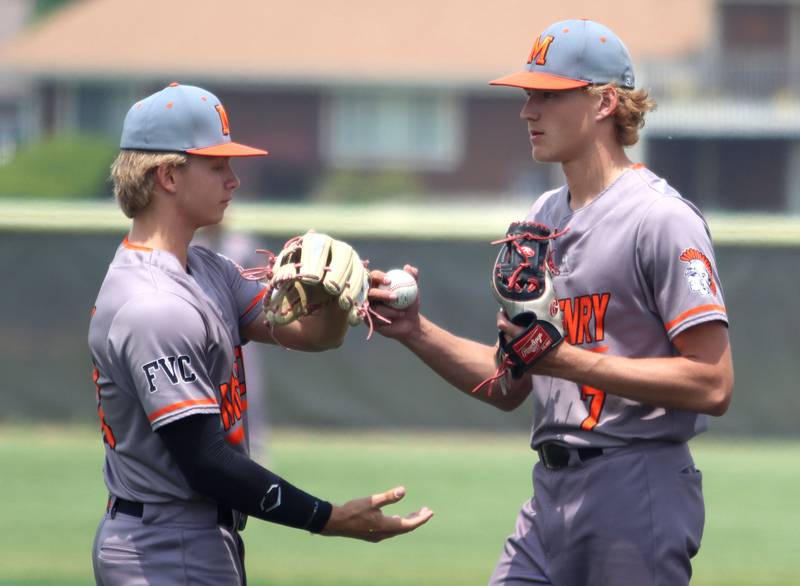 McHenry’s starting pitcher Brandon Shannon, right, hands the ball off to reliever Zachary Readdy against Barrington in IHSA Class 4A Sectional Title Game baseball action at McHenry High School in McHenry on Saturday, June 7, 2025.