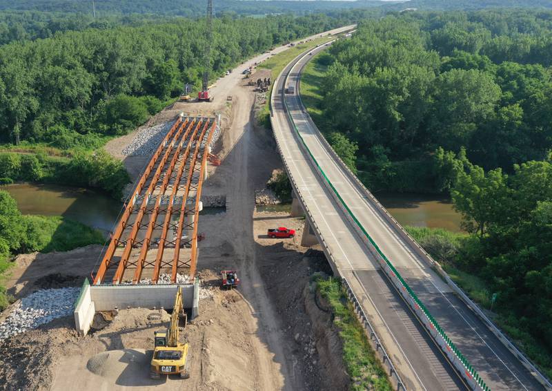An aerial view of crews working on the Interstate 180 bridge crossing over Big Bureau Creek on Tuesday, July 8, 2025 near Tiskilwa. The Illinois Department of Transportation continues to work on the 180 bridges over Bureau Creek and Tiskilwa Bottom Road.  The I-180 work zone is a mile south of the Route 26 interchange. Both the south and northbound bridges are being replaced. Girders have been installed on the bridge. Tiskilwa Bottom Road remains closed under I-180 during the project and traffic should follow the posted detour signs. The 24.2 million project is scheduled to be completed by the end of 2026.