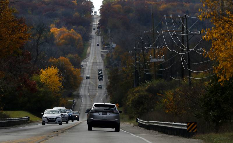 Fall colors lines Route 31, in Crystal Lake, as cars travel along the road.