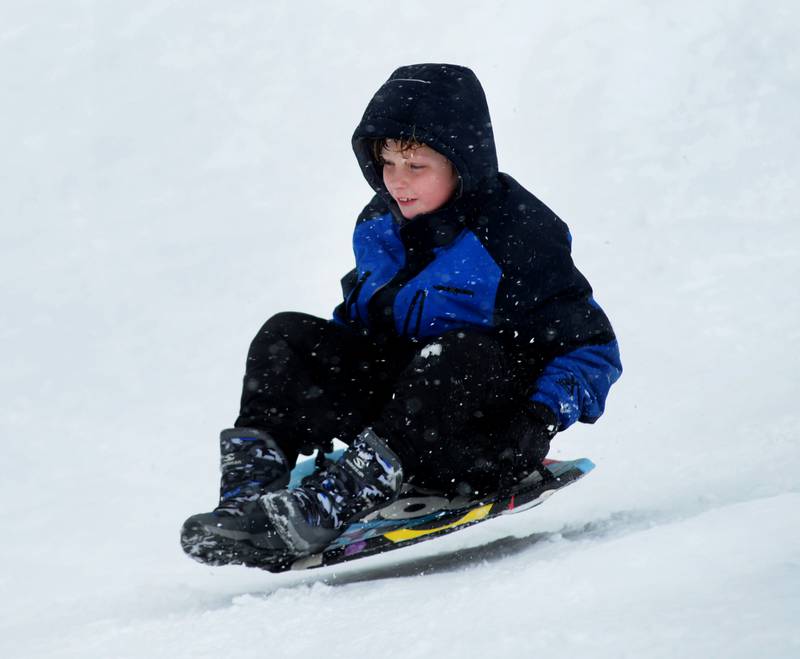 Jace Schwarz, 10, of Oregon, his a bump and grabs some air as he rides his saucer sled down the sledding hill at Oregon Park West on Friday, Jan.12, 2024.