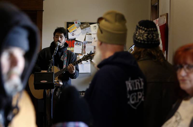 People listen to David “The Jukebox” James sing during a free pre-Thanksgiving luncheon on Wednesday, Nov. 22, 2023, at the Woodstock train depot. This is the second year the meal that was provided through efforts of Warp Corps, MBI Cares, Isabel’s Family Restaurant, and Napoli’s Pizza, all located in Woodstock