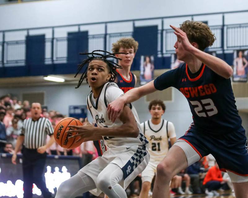 Oswego East's Mason Lockett (23) makes a move underneath the basket during their basketball game between Oswego at Oswego East, Feb 13, 2026 in Oswego.