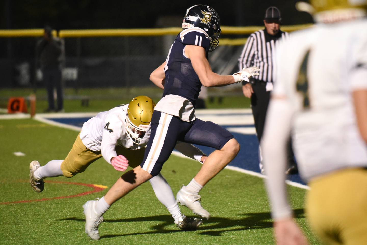 IC Catholic's Grant Bowen (11) evades a tackle attempt from Bishop McNamara's Coen Demack on his way in for a touchdown during an IHSA Class 3A second round playoff game at IC Catholic Friday, Nov. 7, 2025.