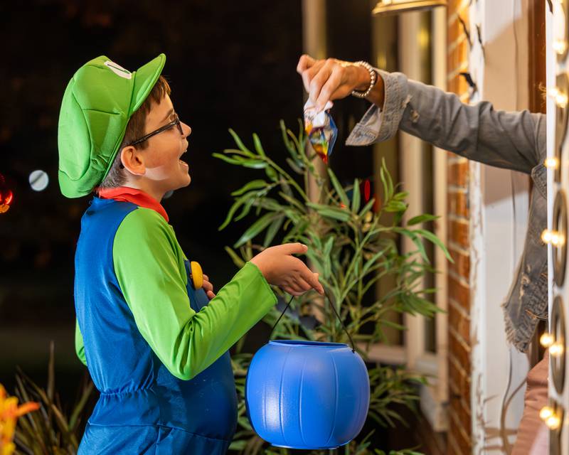 Child yells "Trick-Or-Treat" as he's handed candy by Lynn Zellmer on Friday, October 31, 2025 on Hopkins Ave. in Granville.