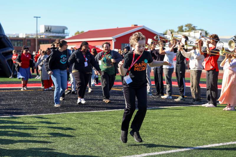 Jake Cells, of Menta Academy, dances to the music played by the Bradley-Bourbonnais marching band at the start of the annual Boilermaker Games, hosted by the Best Buddies club on Wednesday, Oct. 8, 2025, at Bradley-Bourbonnais Community High School.