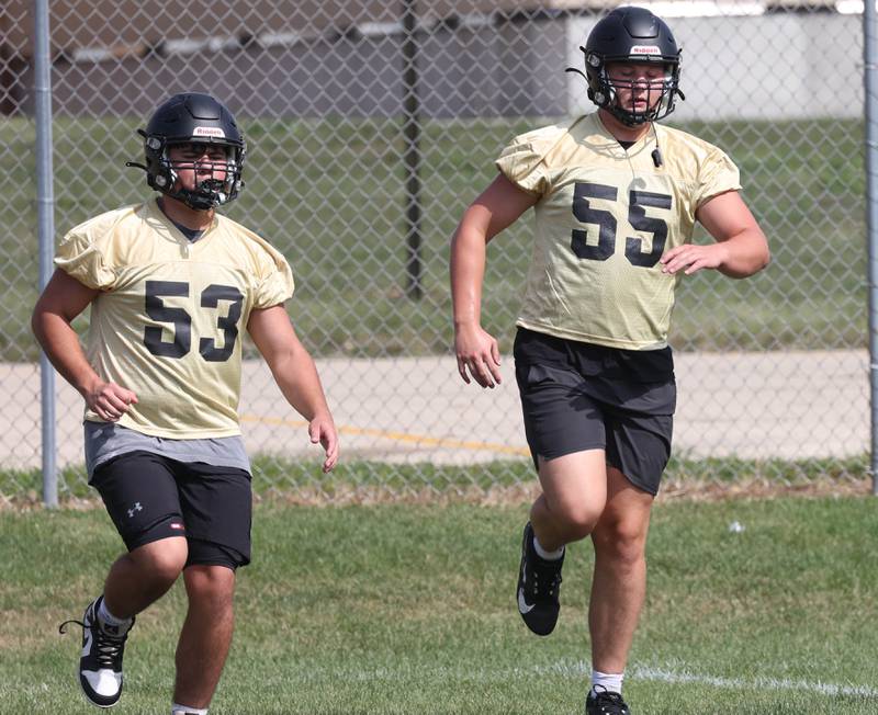 Sycamore’s Will Rosenow (right) warms up with teammates Monday, Aug. 11, 2025, at the start of their first fall practice at the school.