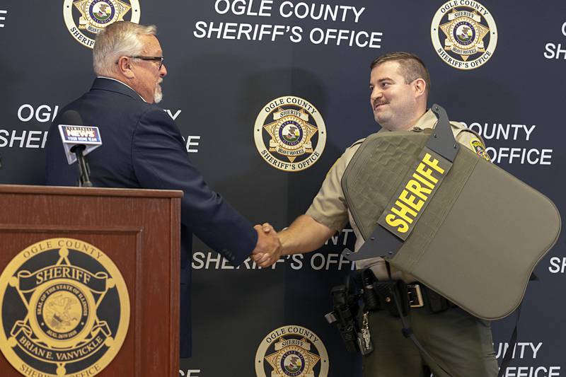 Armor Research Company CEO Ken Hall presents Ogle County Sheriff's Office Sgt. Tad Dominski with a new shield Tuesday, Aug. 20, 2024, at the sheriff’s office in Oregon. Dominski’s shield was damaged by gunfire June 12 in Lost Lake.