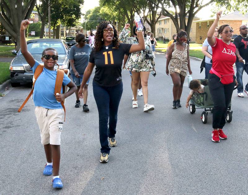 Walkers chant as they march Friday, July 18, 2025, during the DeKalb Peace Walk and Rally. The event, which featured a march, food vendors and music, was held to encourage the community to work together against gun violence.