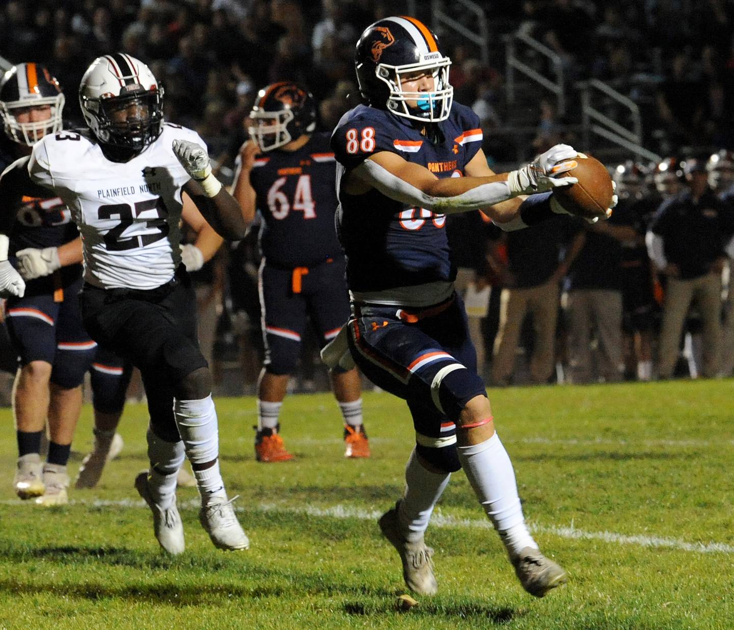 Oswego tight end Deakon Tonielli (88) nabs a reception in front of Plainfield North line backer Gerald Floyd (23) for an easy touchdown during a varsity football game at Oswego High School on Friday.