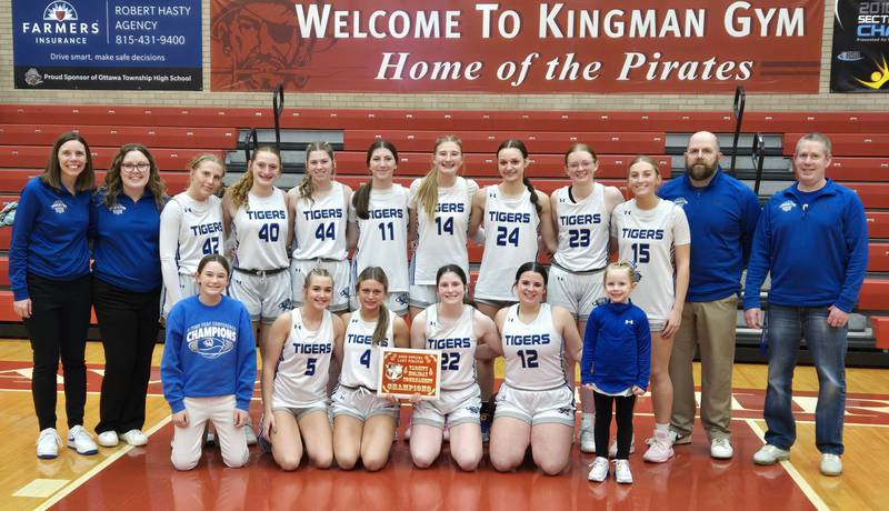 Members of the Princeton girls basketball team pose with the 2025 Lady Pirate Varsity Holiday Tournament Championship plaque on Tuesday, Dec. 23, 2025 in Kingman Gymnasium at Ottawa High School.