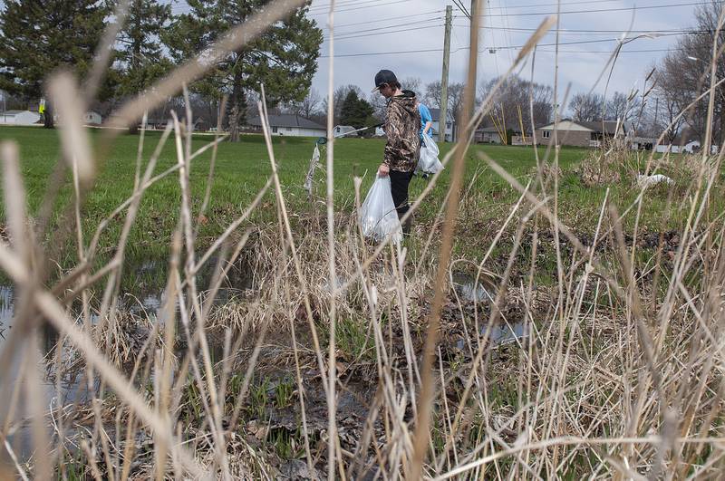 Connor Fritz, 11, wades through deep water at Centennial Park Saturday while helping to clean up the area with the Rock River Development Authority.